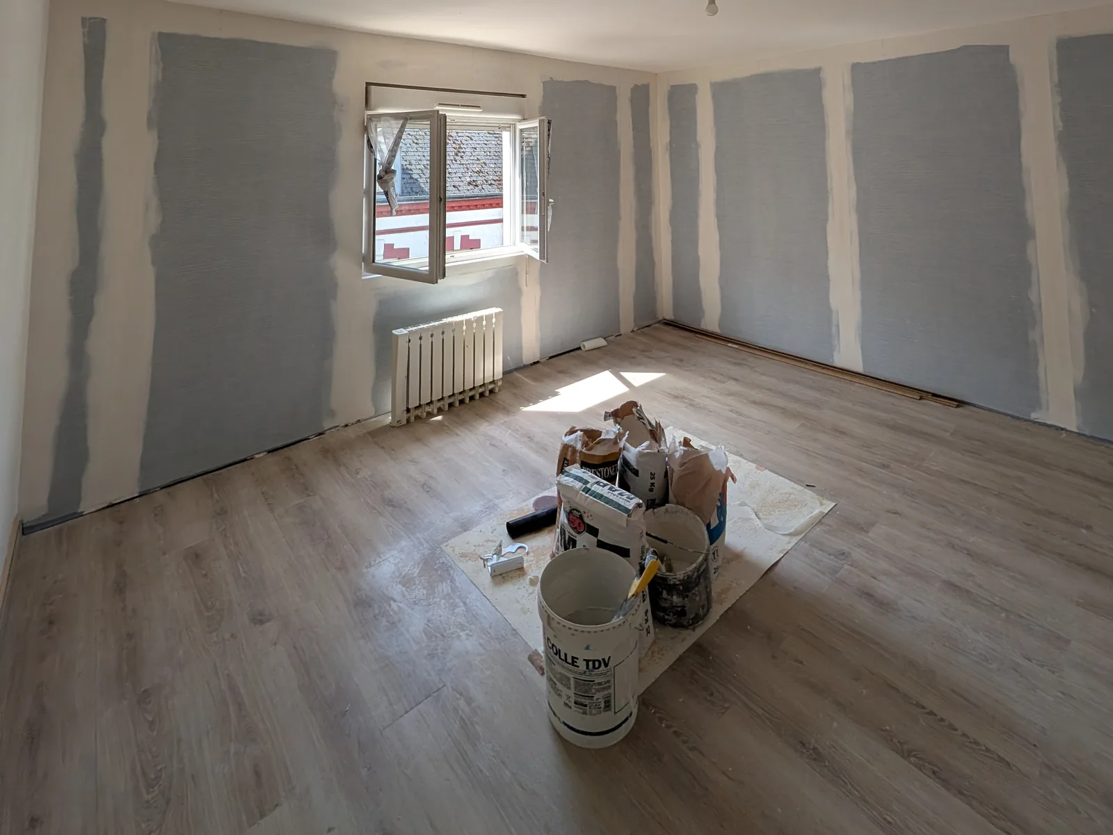 La même pièce avant peinture : murs en préparation, bandes de placo enduites