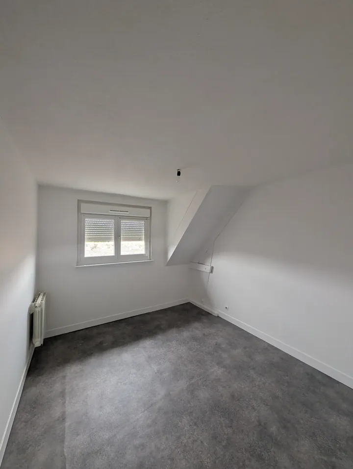 Chambre mansardée repeinte en blanc avec sol souple gris posé