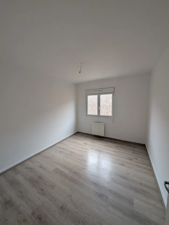 Chambre rénovée avec parquet stratifié posé et murs peints en blanc