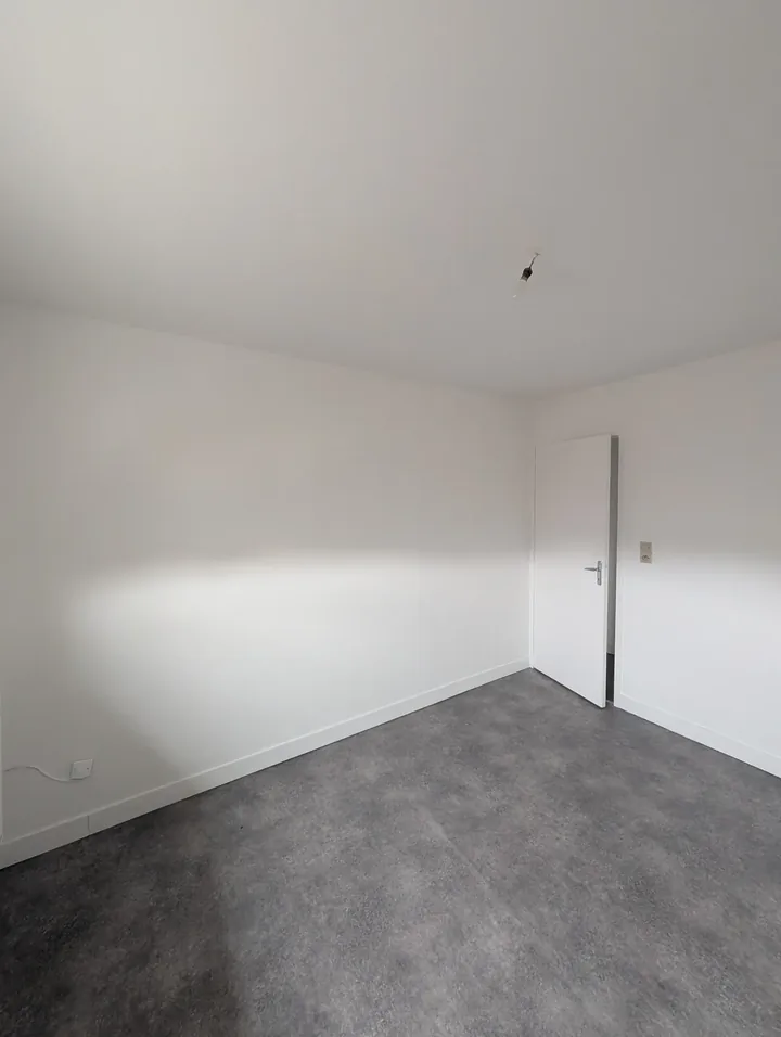 Chambre repeinte en blanc avec sol vinyle effet béton gris