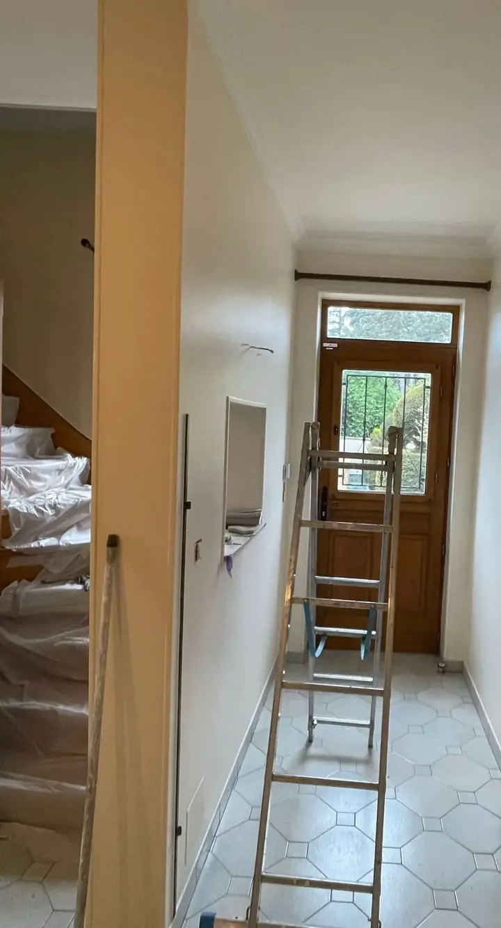 Entrée et couloir intégralement protégés par des bâches pendant le chantier