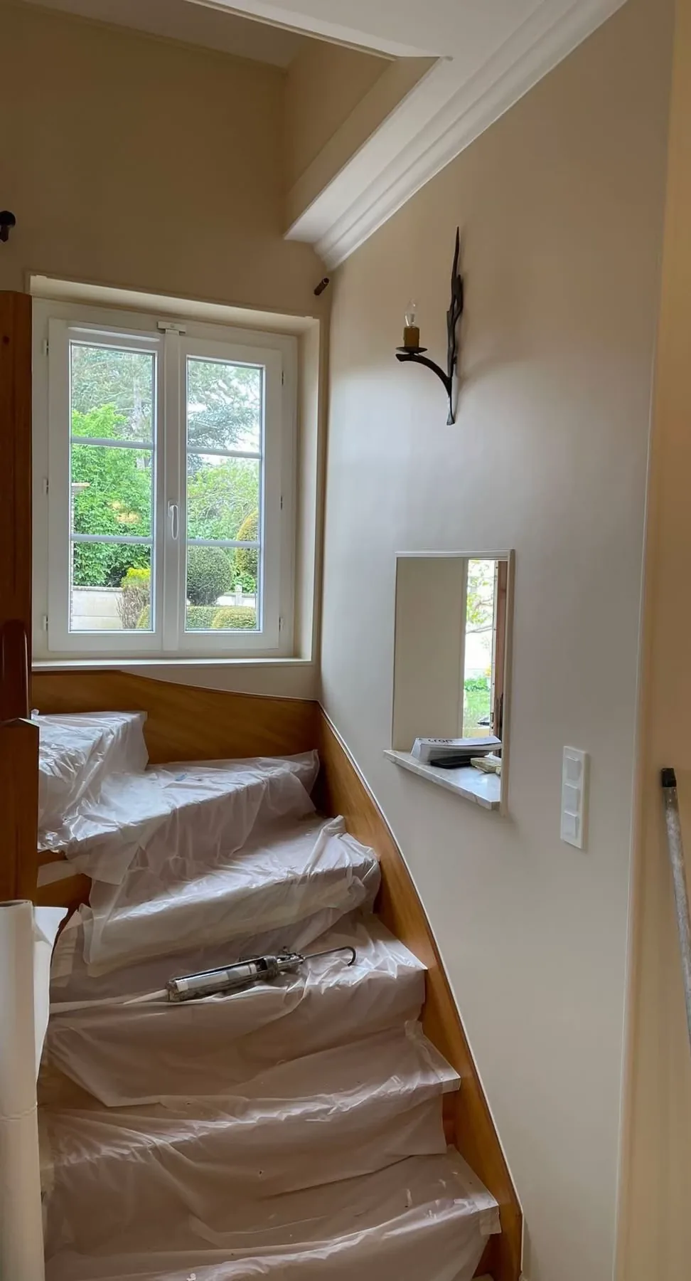 Escalier intégralement protégé par des bâches pendant un chantier de peinture
