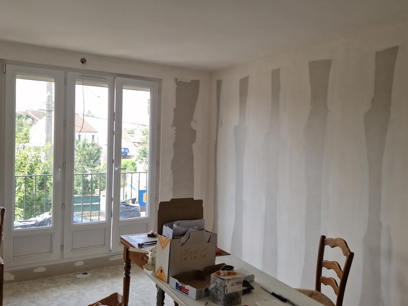 Séjour en cours de rénovation : murs préparés à l'enduit avant la mise en peinture