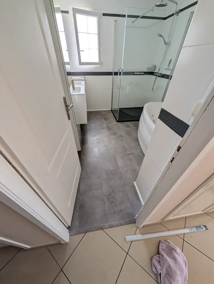 Salle de bain avec sol vinyle gris effet béton posé